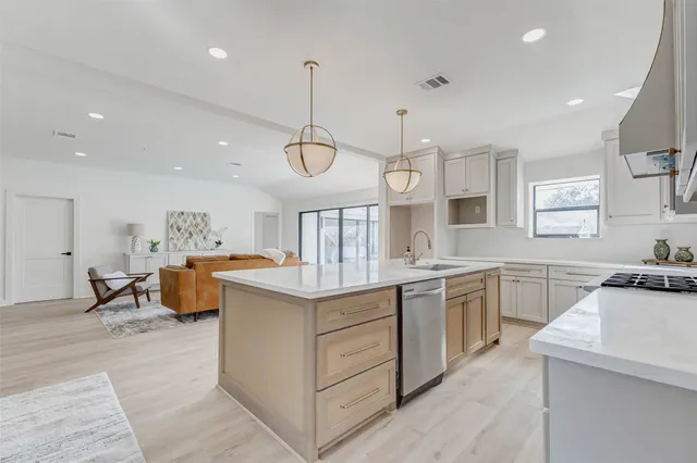 a kitchen with stainless steel appliances granite countertop a sink and dishwasher a stove with wooden floor