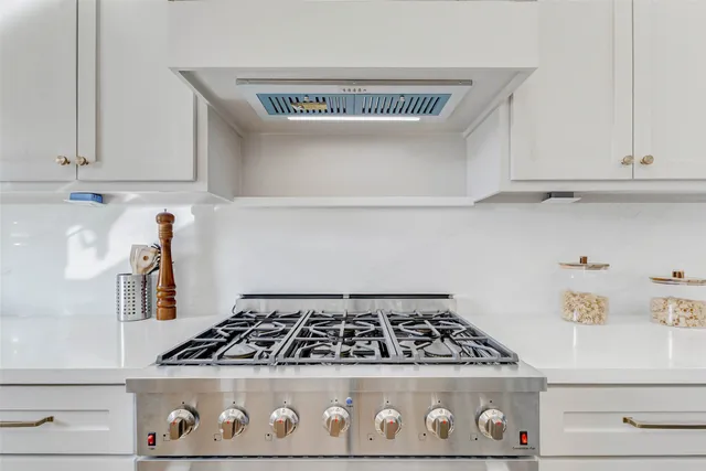 a stove top oven sitting inside of a kitchen