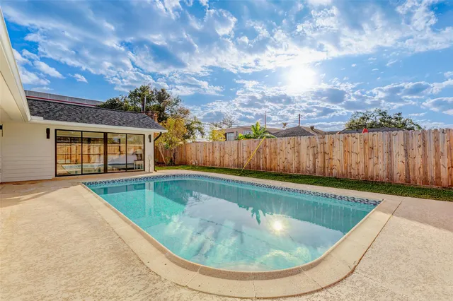 a view of yard with swimming pool and green space