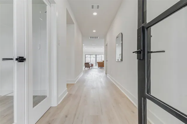 a view of a hallway with wooden floor and staircase