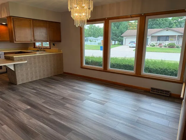 a view of a kitchen with a stove wooden floor and a large window