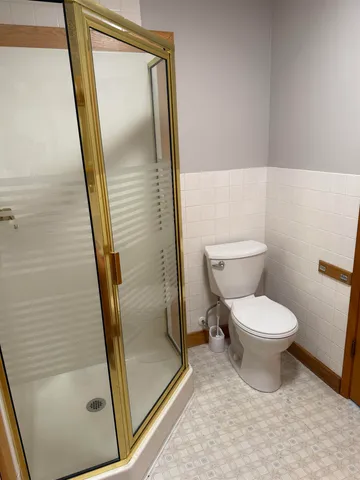 a bathroom with a toilet and a shower