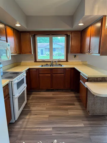 a large kitchen with wooden cabinets and a sink
