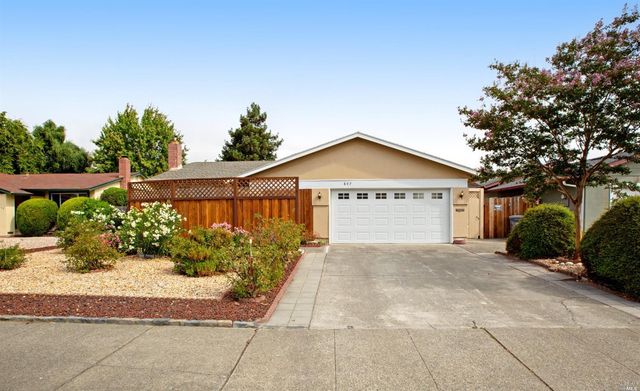 a view of a house with a yard and potted plants