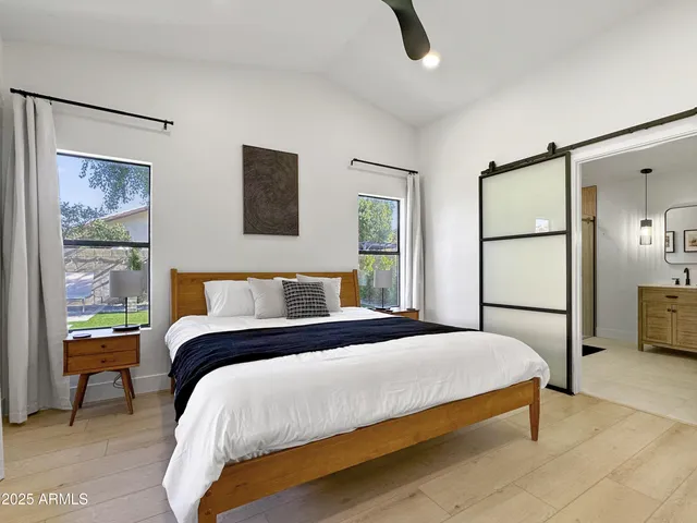 a bedroom with a bed and a large window