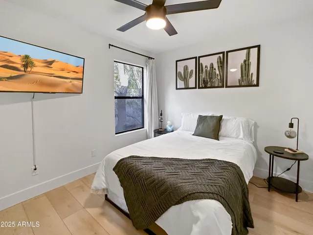 a bedroom with a bed and painting on the wall