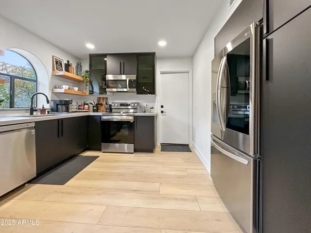 a kitchen with stainless steel appliances granite countertop a refrigerator and a stove top oven