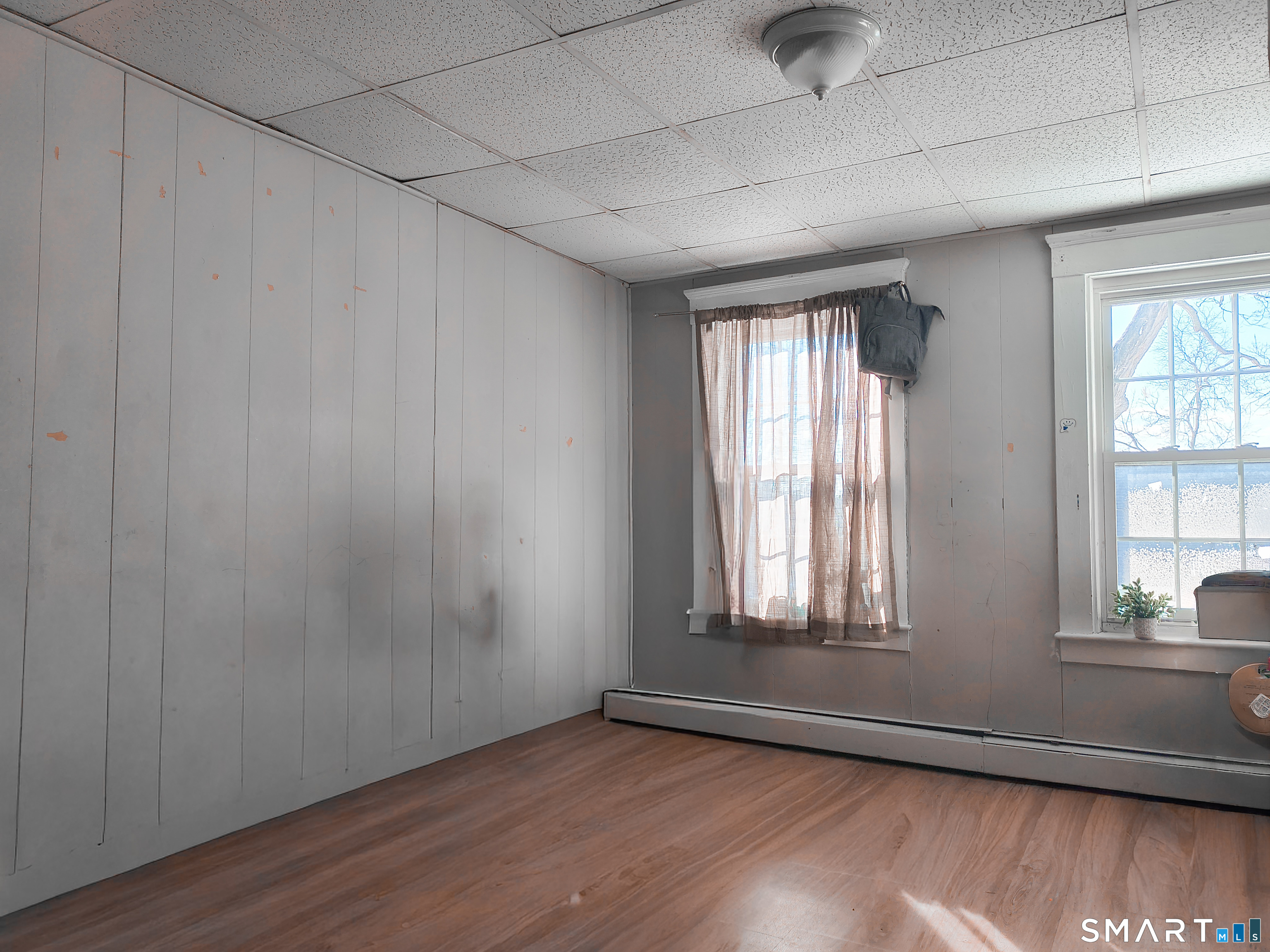 70 Walnut Street Putnam, CT 06260 - Photo 15 of 20 an empty room with wooden floor and windows