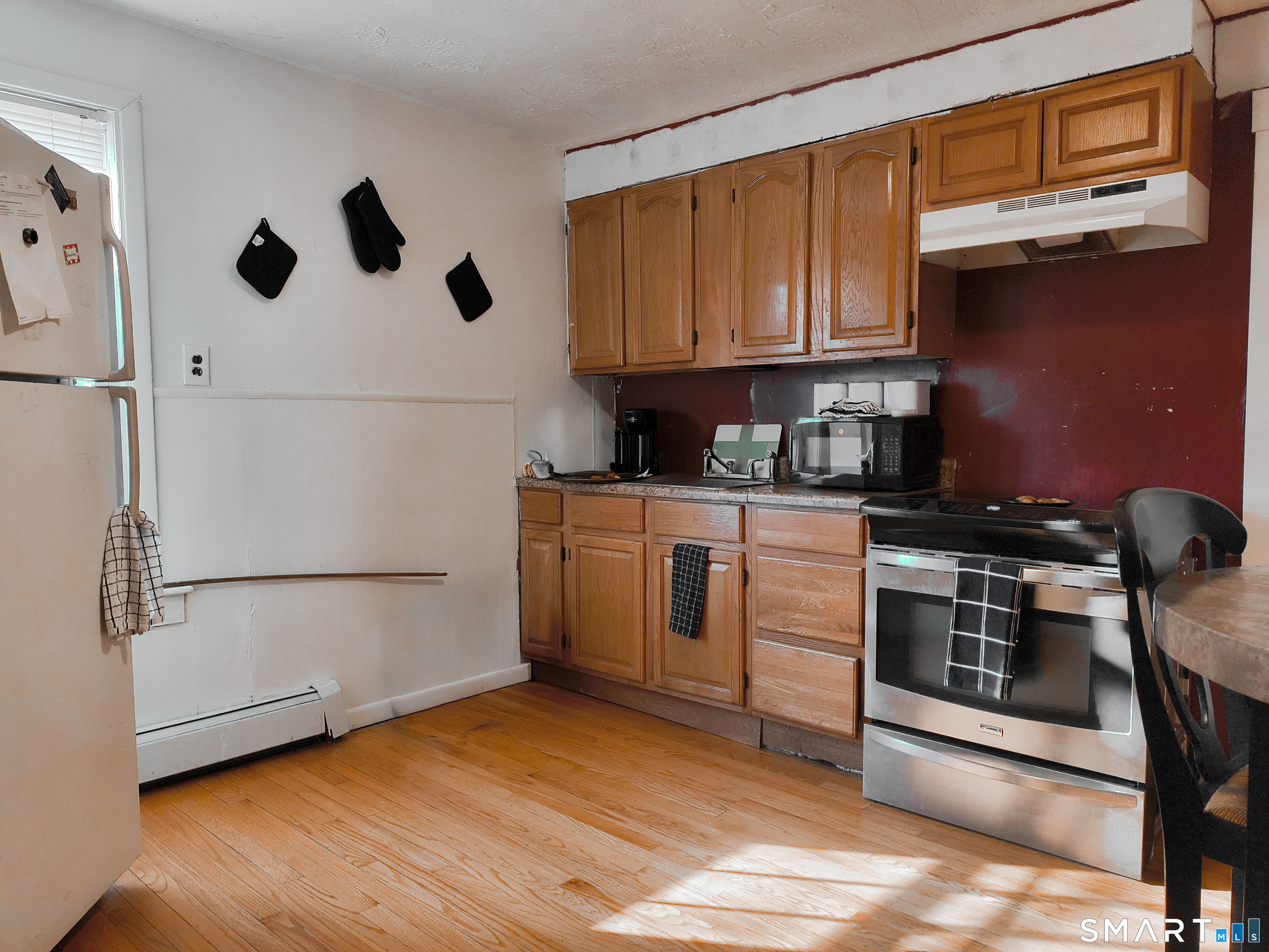 70 Walnut Street Putnam, CT 06260 - Photo 3 of 20 a kitchen with granite countertop a stove a sink and a refrigerator