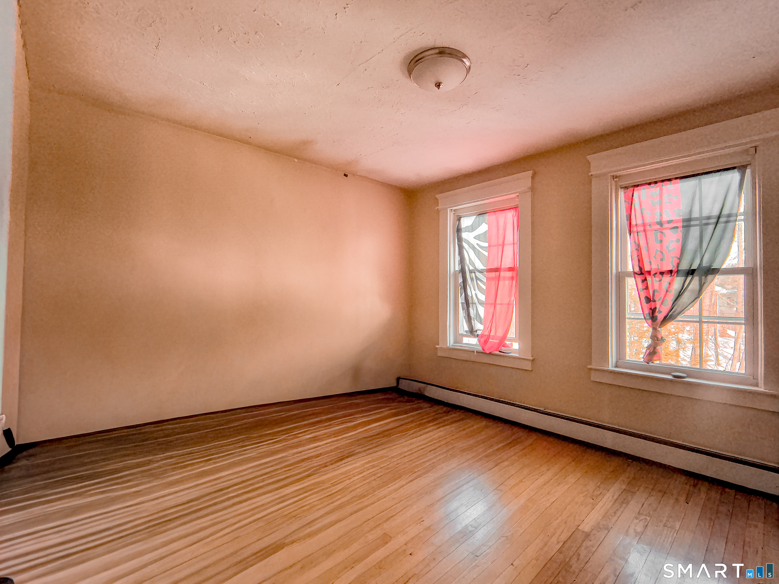 70 Walnut Street Putnam, CT 06260 - Photo 5 of 20 an empty room with wooden floor and windows