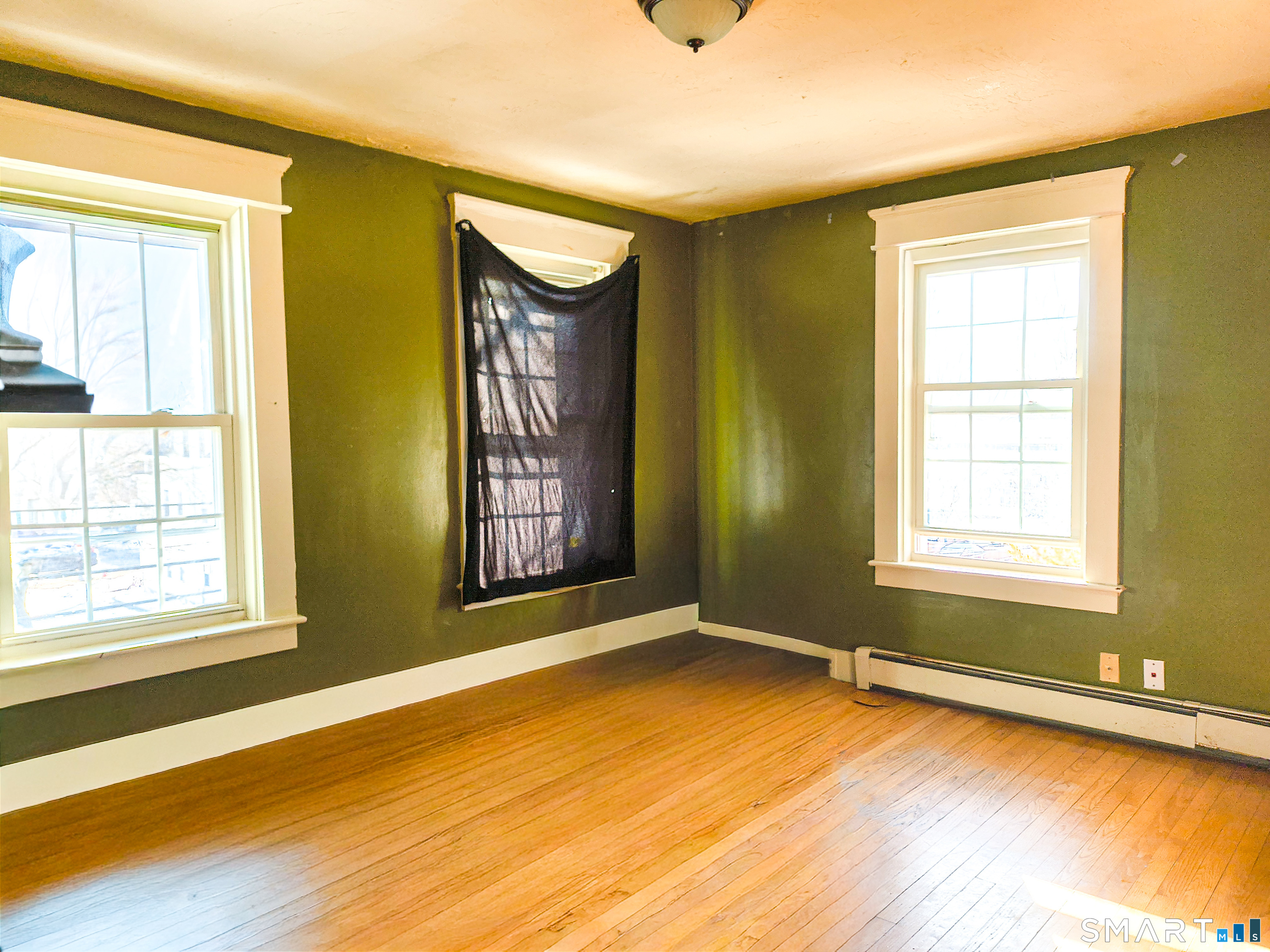 70 Walnut Street Putnam, CT 06260 - Photo 7 of 20 a view of an empty room with window and wooden floor