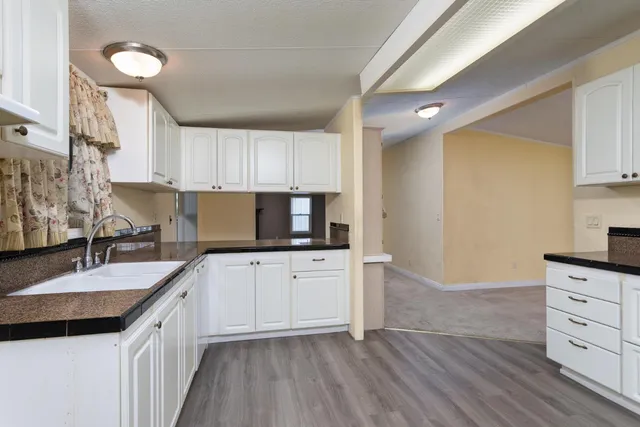 a kitchen with granite countertop a sink stove and cabinets