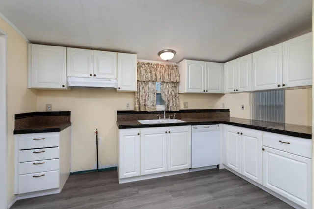 a kitchen with granite countertop a white cabinets and sink