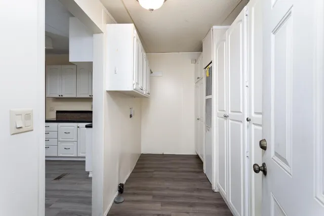 a view of a kitchen with white cabinets and stainless steel appliances