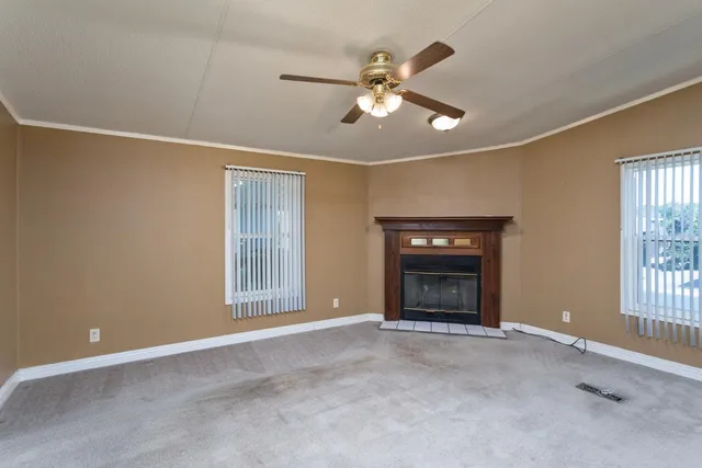 a view of an empty room with a window and fireplace