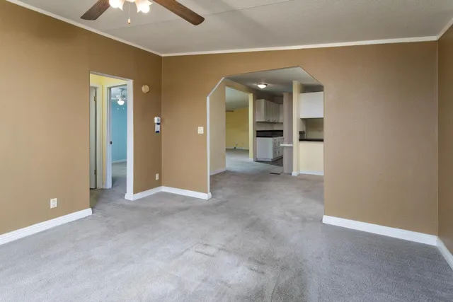 an empty room with fan and entrance