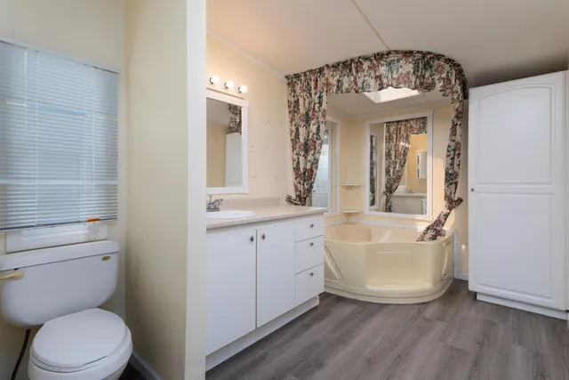 a spacious bathroom with a toilet sink and mirror