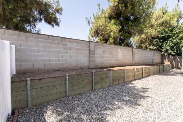 a view of backyard with wooden fence
