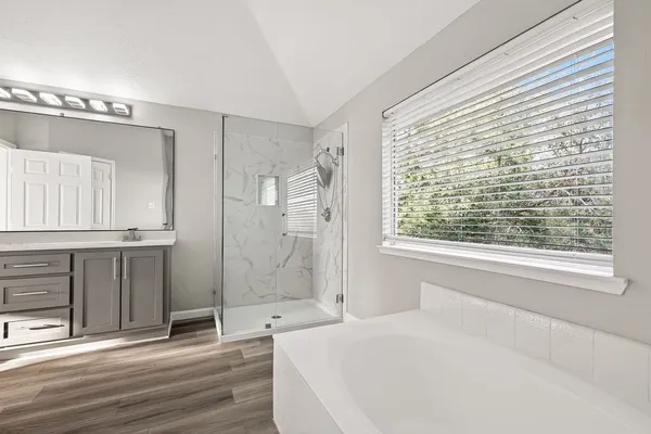a bathroom with a tub shower and sink