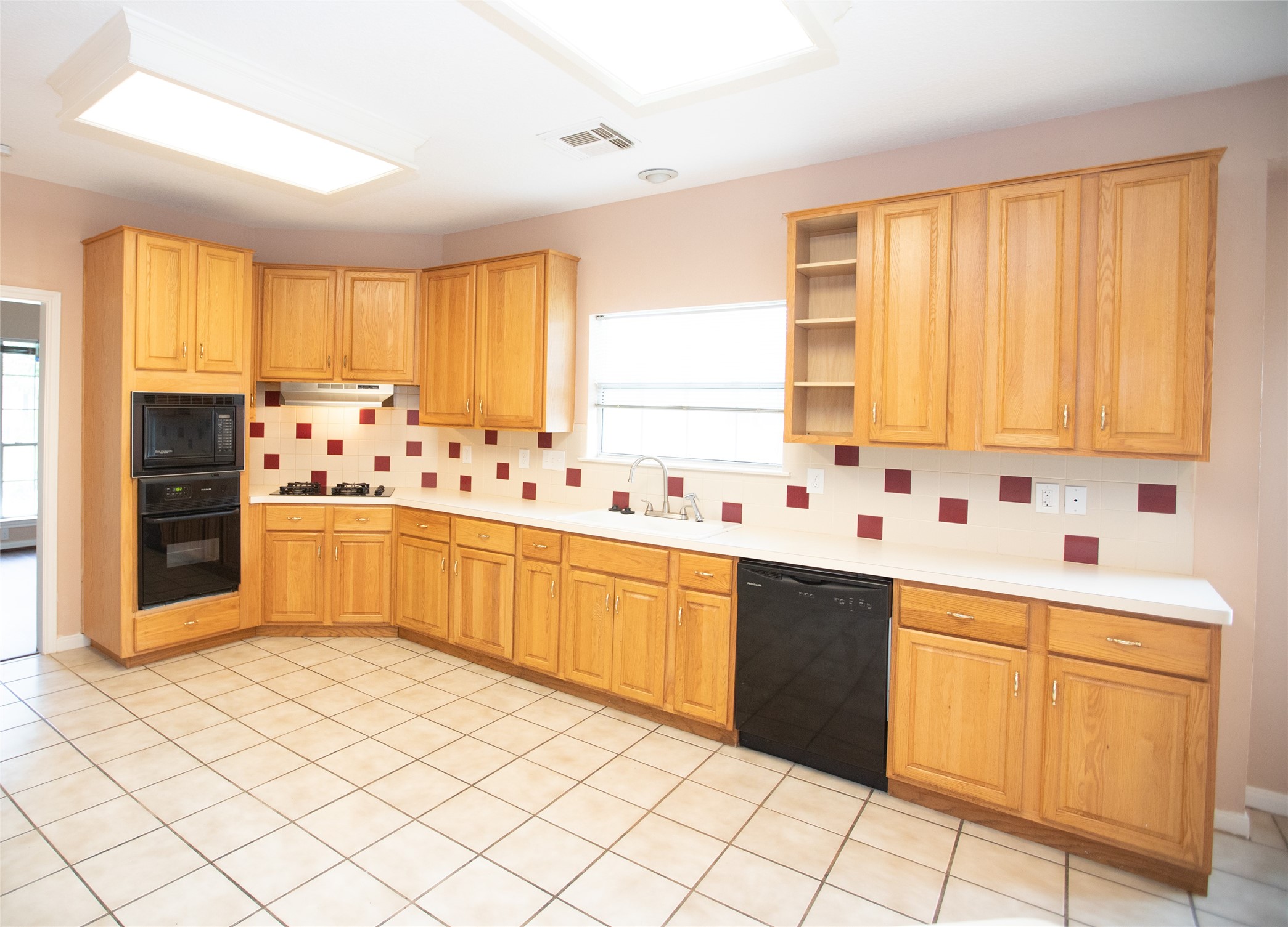 8615 Mile Run Road Humble, TX 77346 - Photo 11 of 16 a kitchen with stainless steel appliances a sink window and cabinets