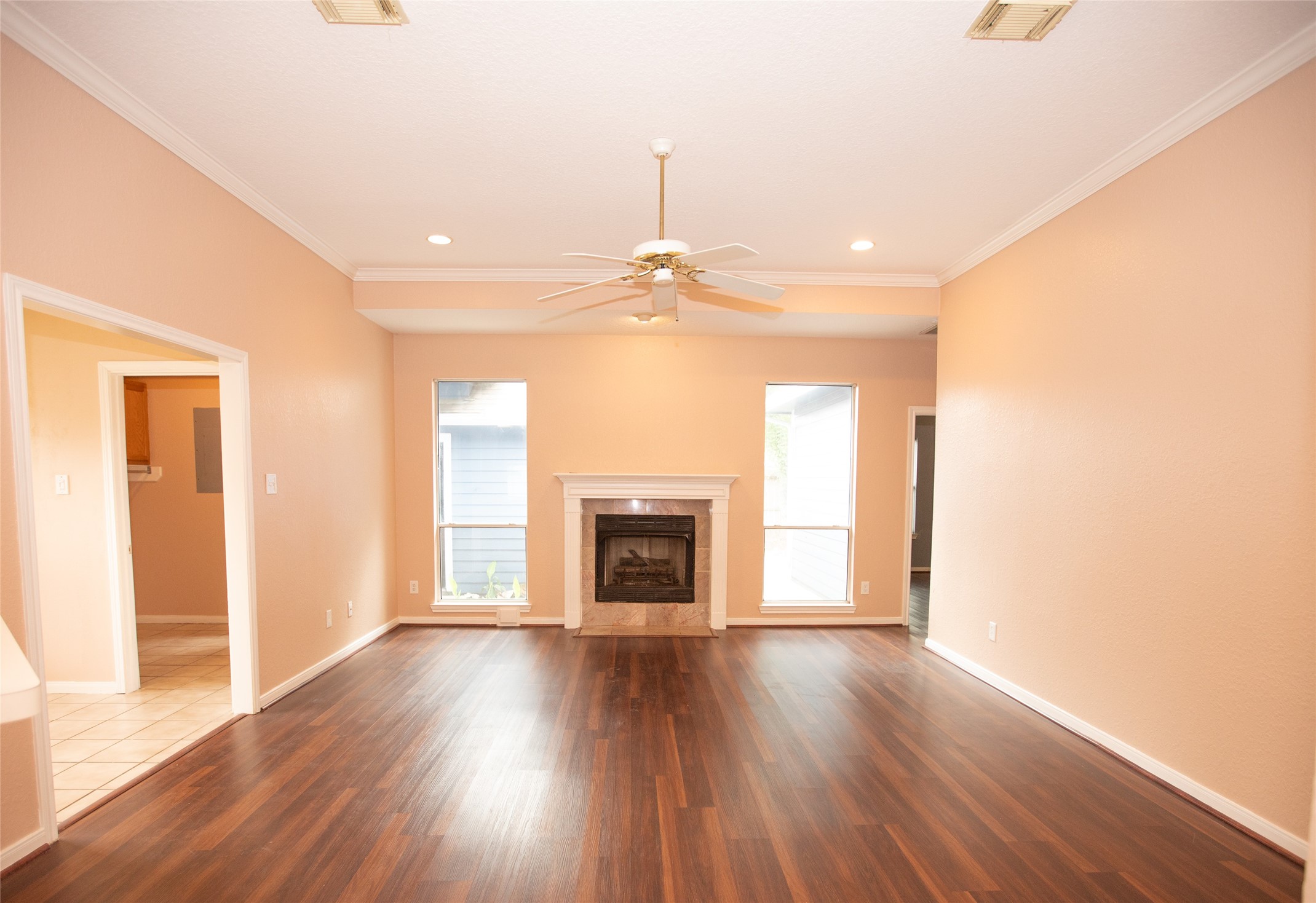 8615 Mile Run Road Humble, TX 77346 - Photo 5 of 16 an empty room with wooden floor fireplace and windows