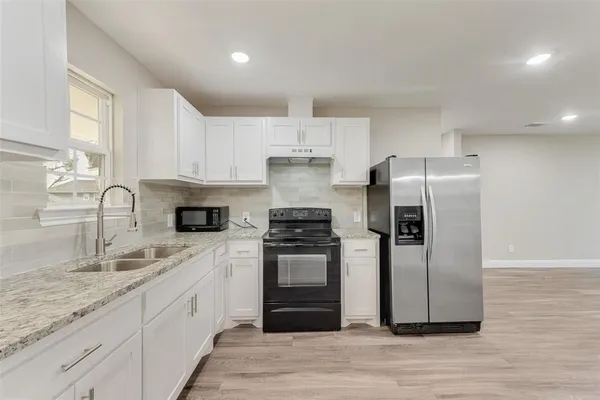 a kitchen with stainless steel appliances granite countertop a sink stove and refrigerator