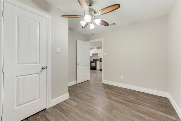 a view of an empty room with wooden floor