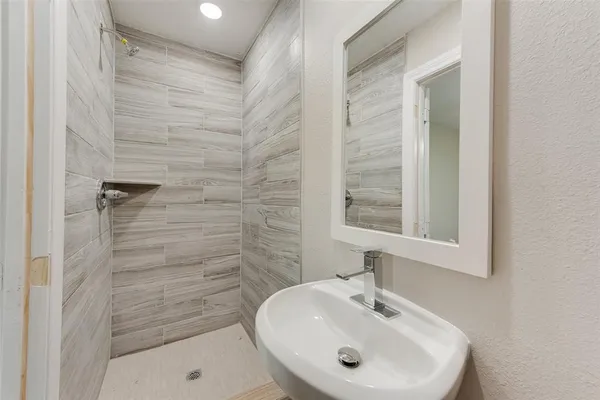 a bathroom with a sink a shower and a mirror