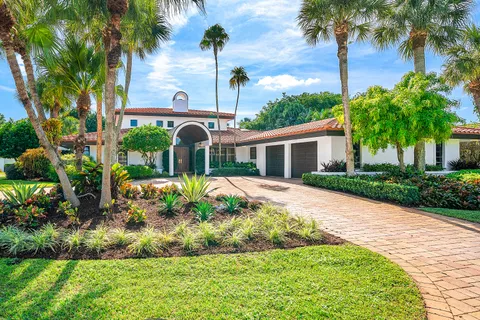 a view of a white house with a yard and potted plants