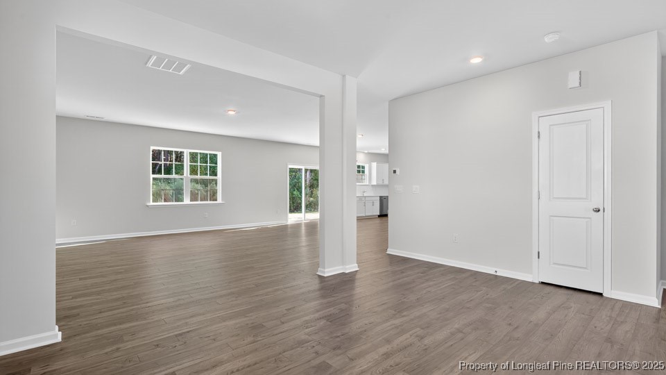 3034 Bayview Drive Vass, NC 28394 - Photo 11 of 47 an empty room with wooden floor and windows