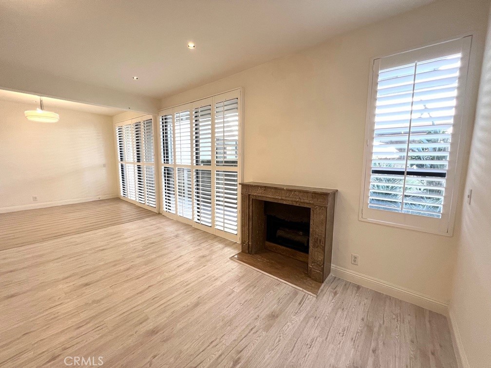 700 South Lake Avenue, Unit 111 Pasadena, CA 91106 - Photo 14 of 40 an empty room with wooden floor fireplace and windows