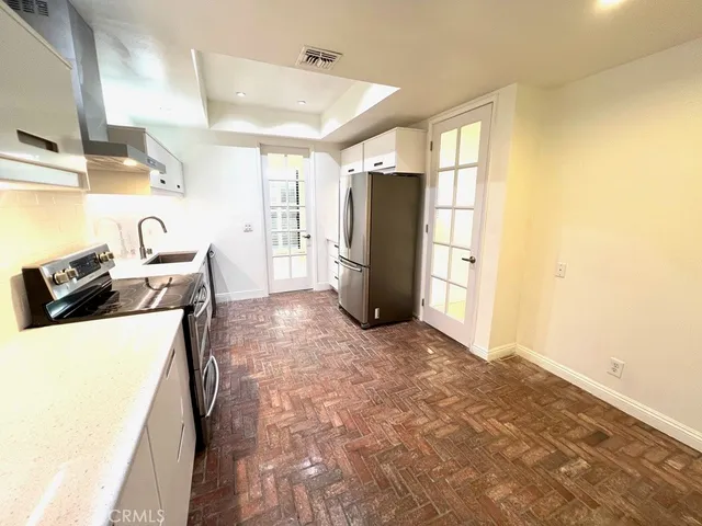 a view of a refrigerator in kitchen and wooden floor