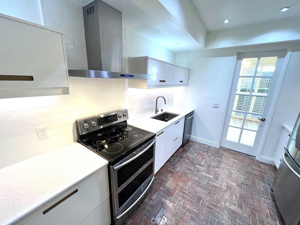 700 South Lake Avenue, Unit 111 Pasadena, CA 91106 - Photo 19 of 40 a kitchen with stainless steel appliances a stove a sink and a refrigerator