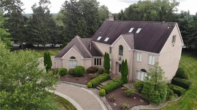a aerial view of a house with a big yard plants and large trees