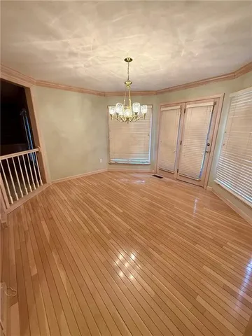 a view of an empty room with wooden floor fireplace and a window