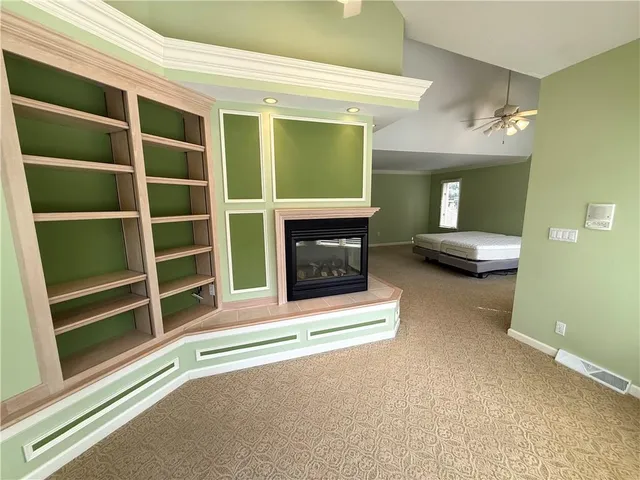 a view of an empty room with a fireplace and a window