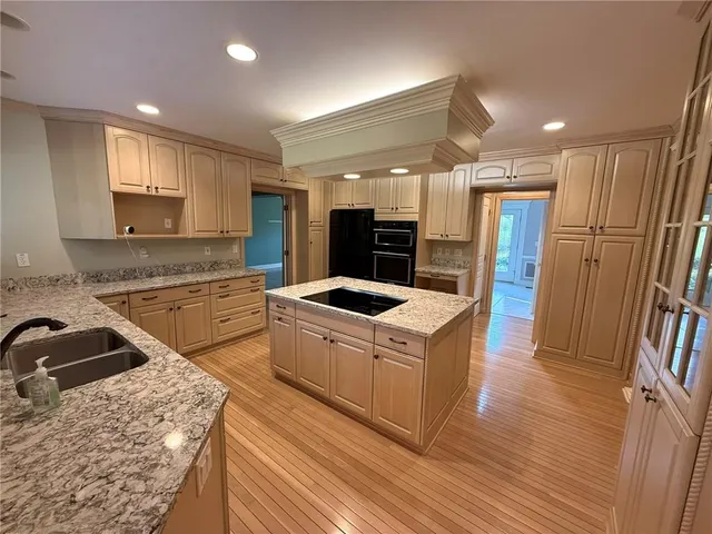a kitchen with stainless steel appliances granite countertop a sink a stove and a refrigerator