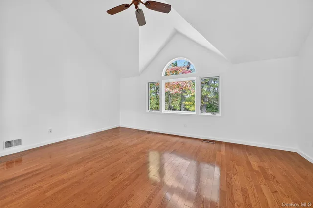 an empty room with window and ceiling fan