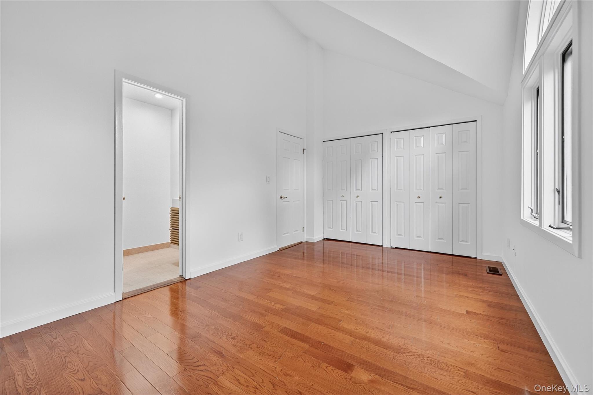 57 Boulder Ridge Road Scarsdale, NY 10583 - Photo 22 of 49 an empty room with wooden floor and windows