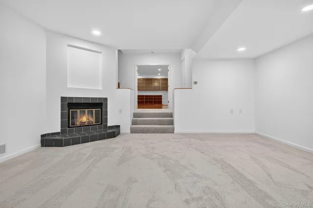 a view of an empty room with a fireplace and a window