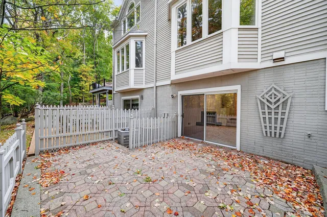 a view of backyard with large trees and wooden fence