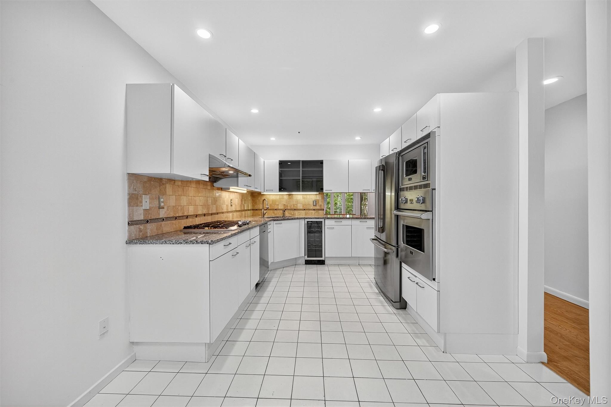 57 Boulder Ridge Road Scarsdale, NY 10583 - Photo 4 of 49 a kitchen with stainless steel appliances granite countertop a sink and cabinets