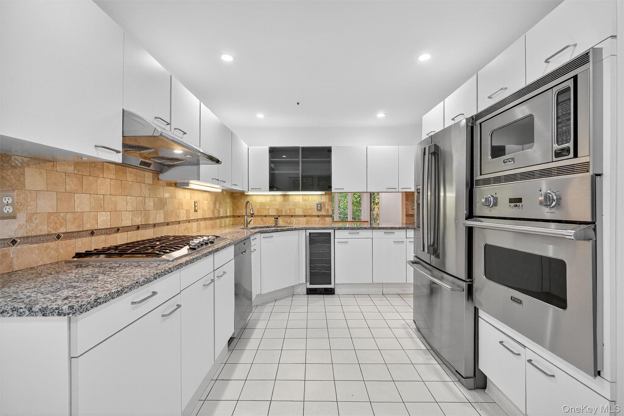 57 Boulder Ridge Road Scarsdale, NY 10583 - Photo 5 of 49 a kitchen with stainless steel appliances granite countertop a stove a sink and a microwave