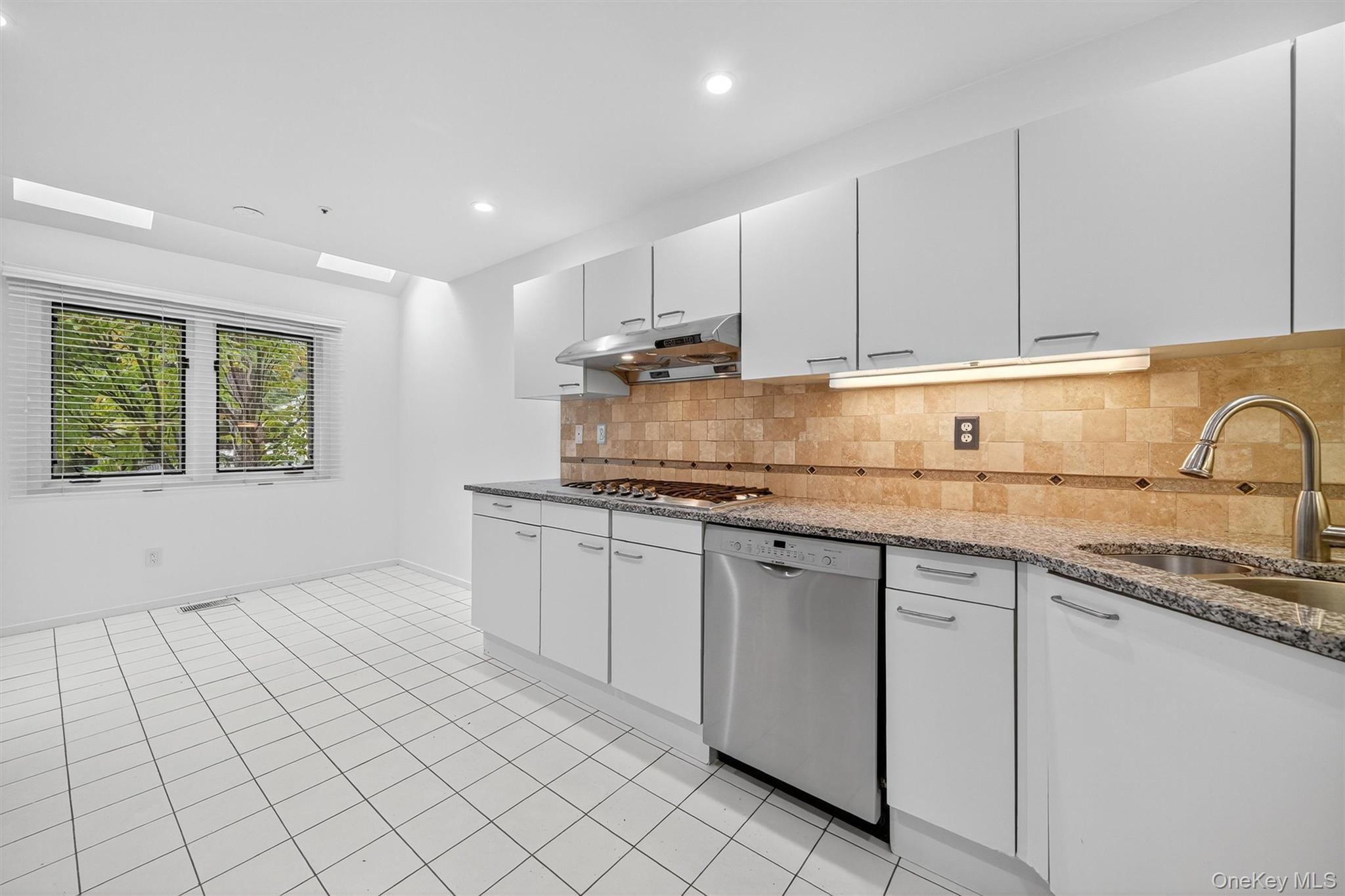 57 Boulder Ridge Road Scarsdale, NY 10583 - Photo 6 of 49 a kitchen with granite countertop white cabinets and white appliances