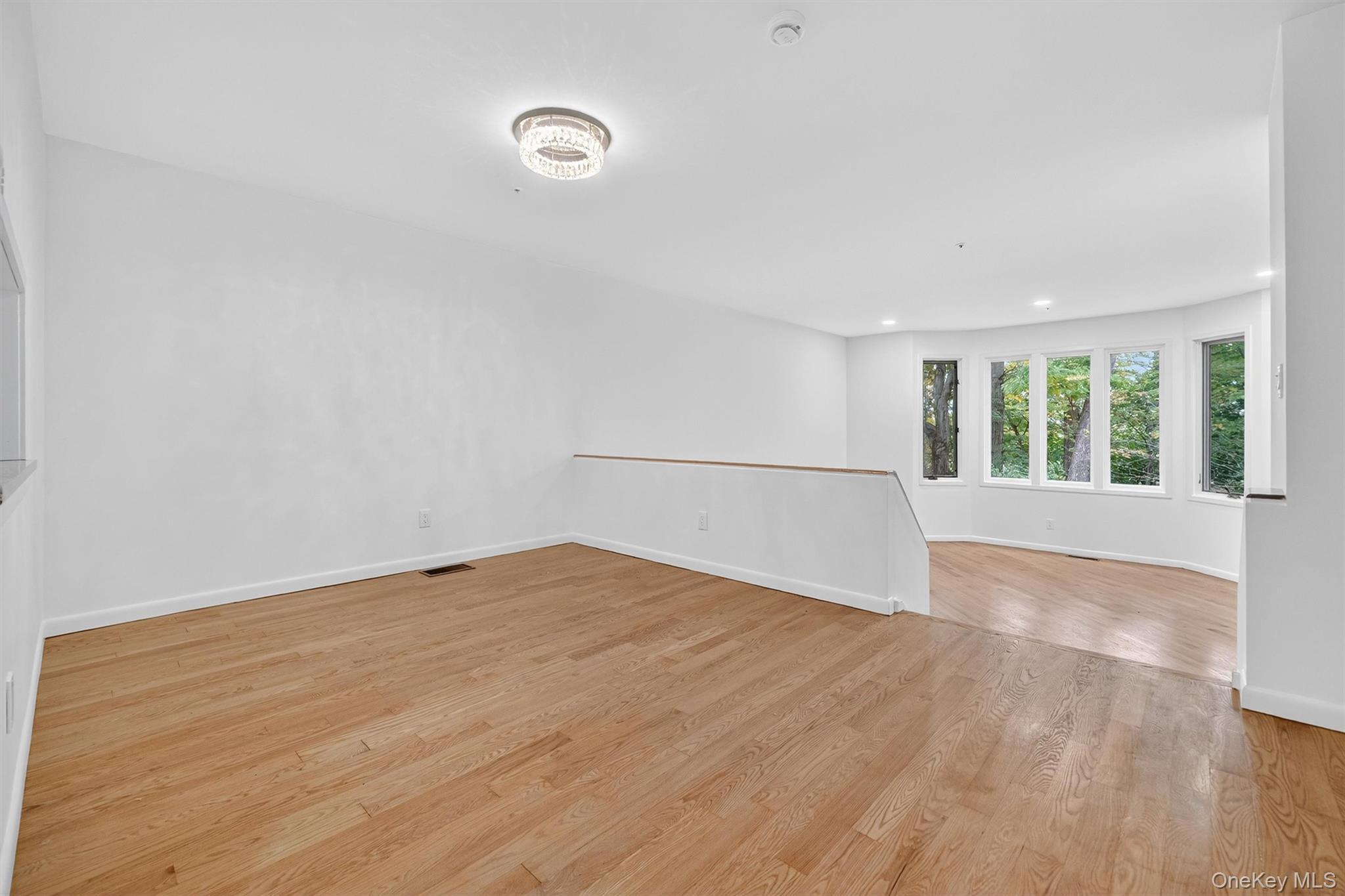 57 Boulder Ridge Road Scarsdale, NY 10583 - Photo 7 of 49 a view of an empty room with wooden floor and a window