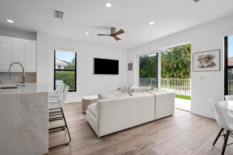 a living room with stainless steel appliances furniture and a flat screen tv