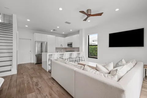 a view of a dining room and livingroom with furniture wooden floor a chandelier