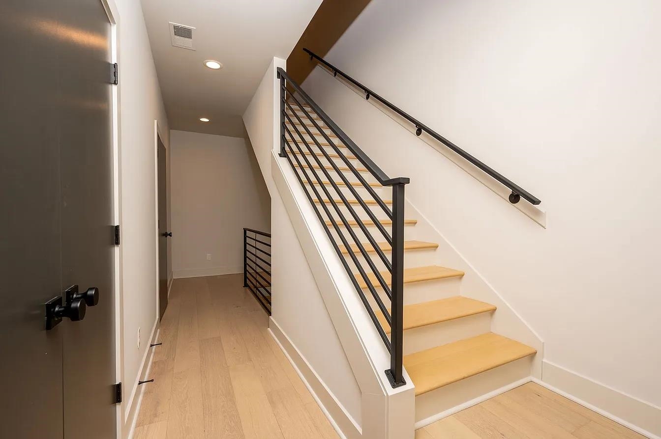 752 Meda Street Memphis, TN 38104 - Photo 10 of 18 Modern staircase featuring light wood treads and a contemporary black metal railing