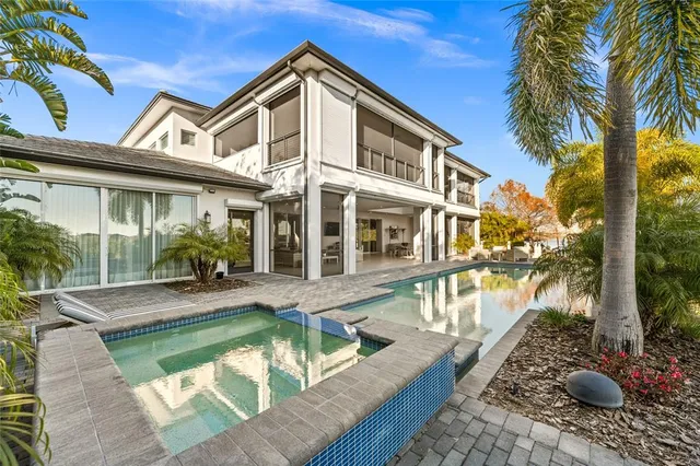 a view of a house with pool and sitting area