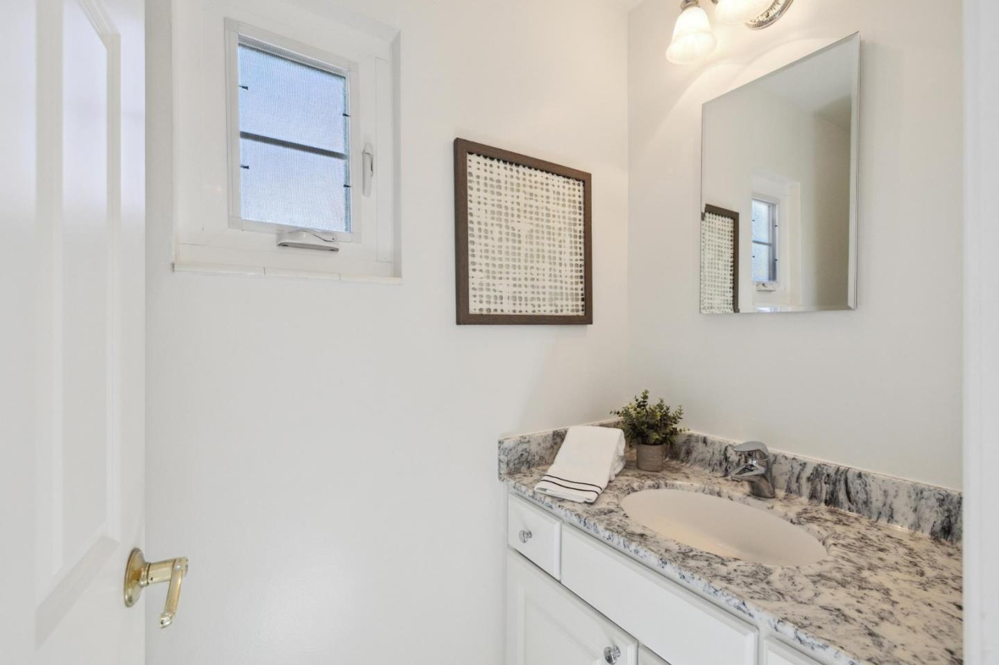 595 Anza Street Mountain View, CA 94041 - Photo 47 of 72 a bathroom with a granite countertop sink and a mirror